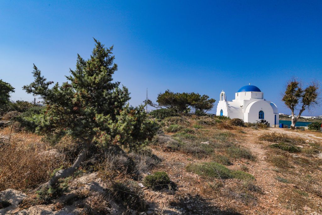 Agia Marina Greek Christian whitewashed church with traditional architecture of Cyclades islands on a hill over the port of Antiparos island that is located near Paros island. Its name day is celebrated every year on July 17 with many events and happenings like traditional music concerts, dance but also swimming or sailboat races. The island is popular to tourists, celebrities and doesn't not have a huge wave of visitors like nearby islands. (Photo by Nicolas Economou/NurPhoto via Getty Images)