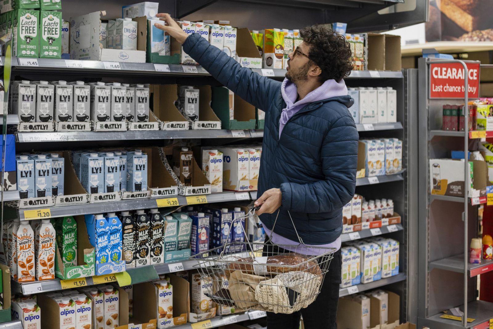 Man shopping in a supermarket, choosing a vegan milk (Photo: Getty Images)