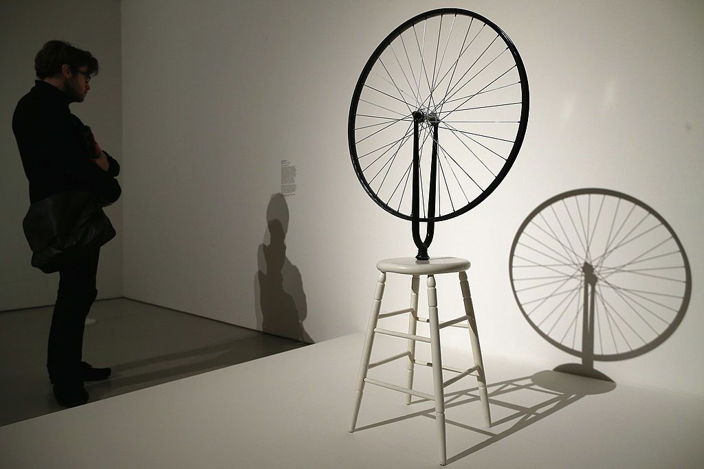 LONDON, ENGLAND - FEBRUARY 13: A visitor reads notes related to the piece of work by Marcel Duchamp entitled 'Bicycle Wheel' during a press preview of 'The Bride and the Bachelors' exhibition at the Barbican Art Gallery on February 13, 2013 in London, England. The piece makes up a selection of works by artists and choreographers including Marcel Duchamp, Merce Cunningham, John Cage, Robert Rauschenberg and Jasper Johns, and runs at the Barbican Art Gallery until June 9, 2013. (Photo by Dan Kitwood/Getty I