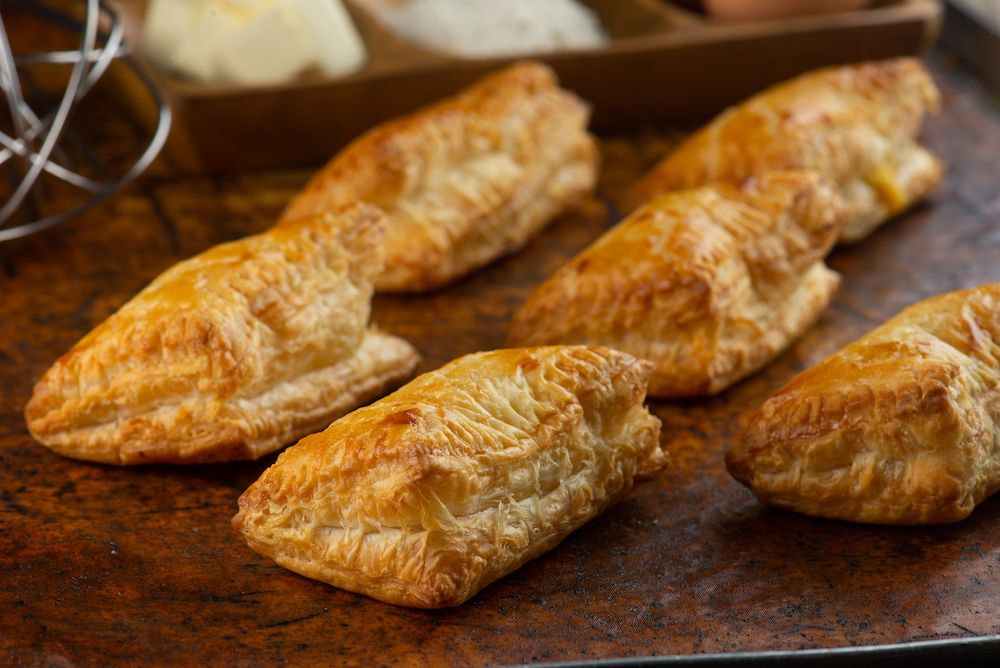 Puff pastry apple pastry turnovers for dessert on a wooden table