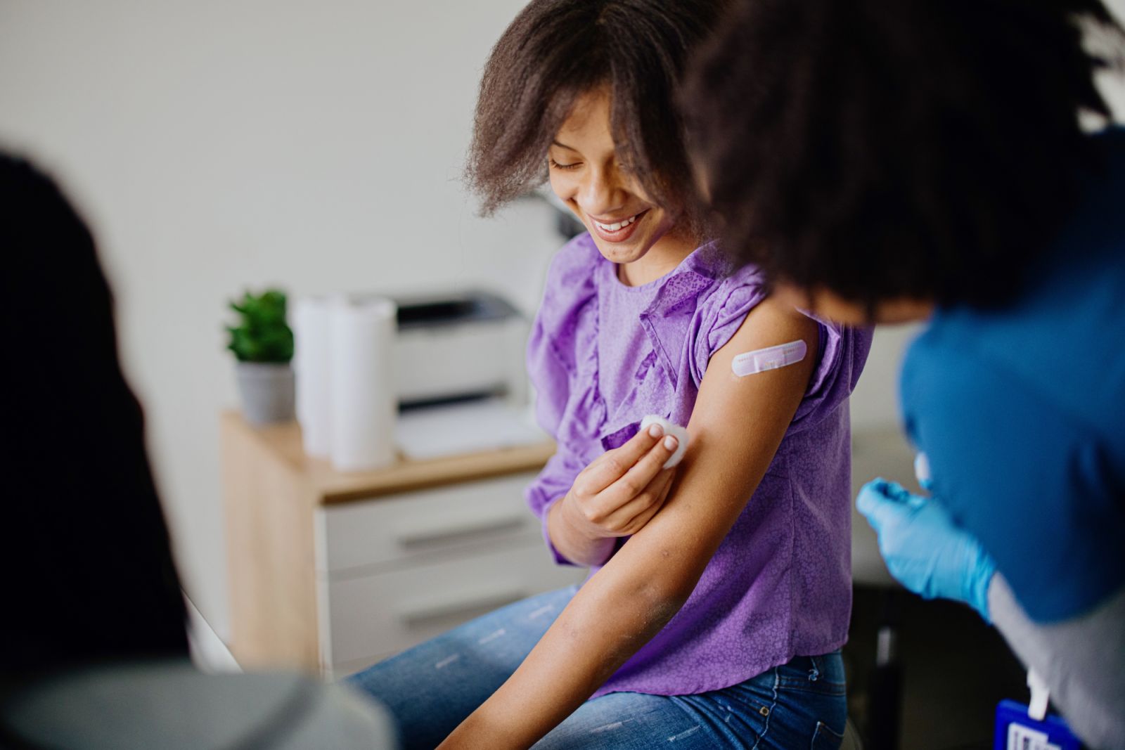 Teen girl getting her HPV vaccine at doctor’s office while accompanied by her mother (Photo: Getty Images)