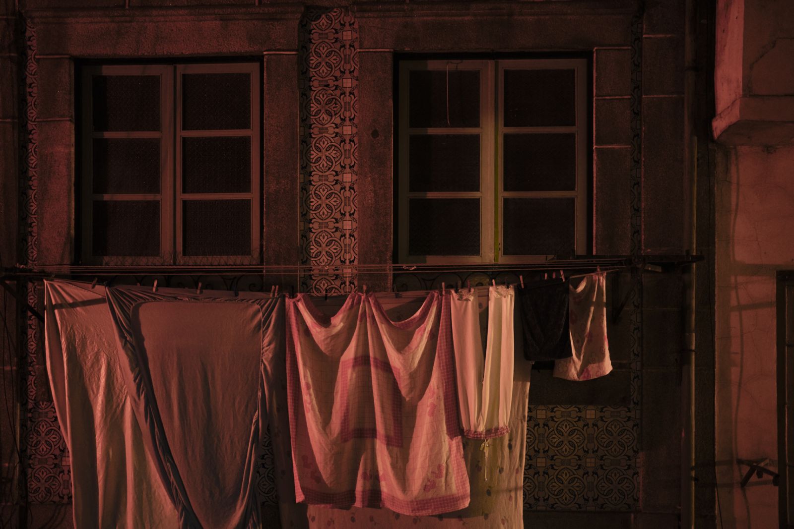 Old balcony on a night street in oporto with clothes hanging on it