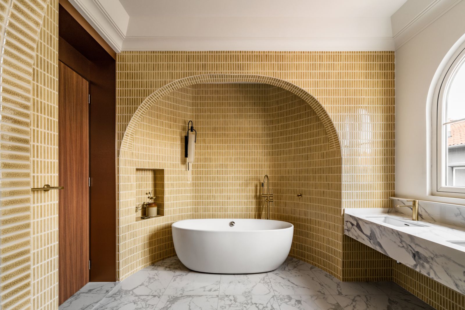 The bathroom echoes the archway theme