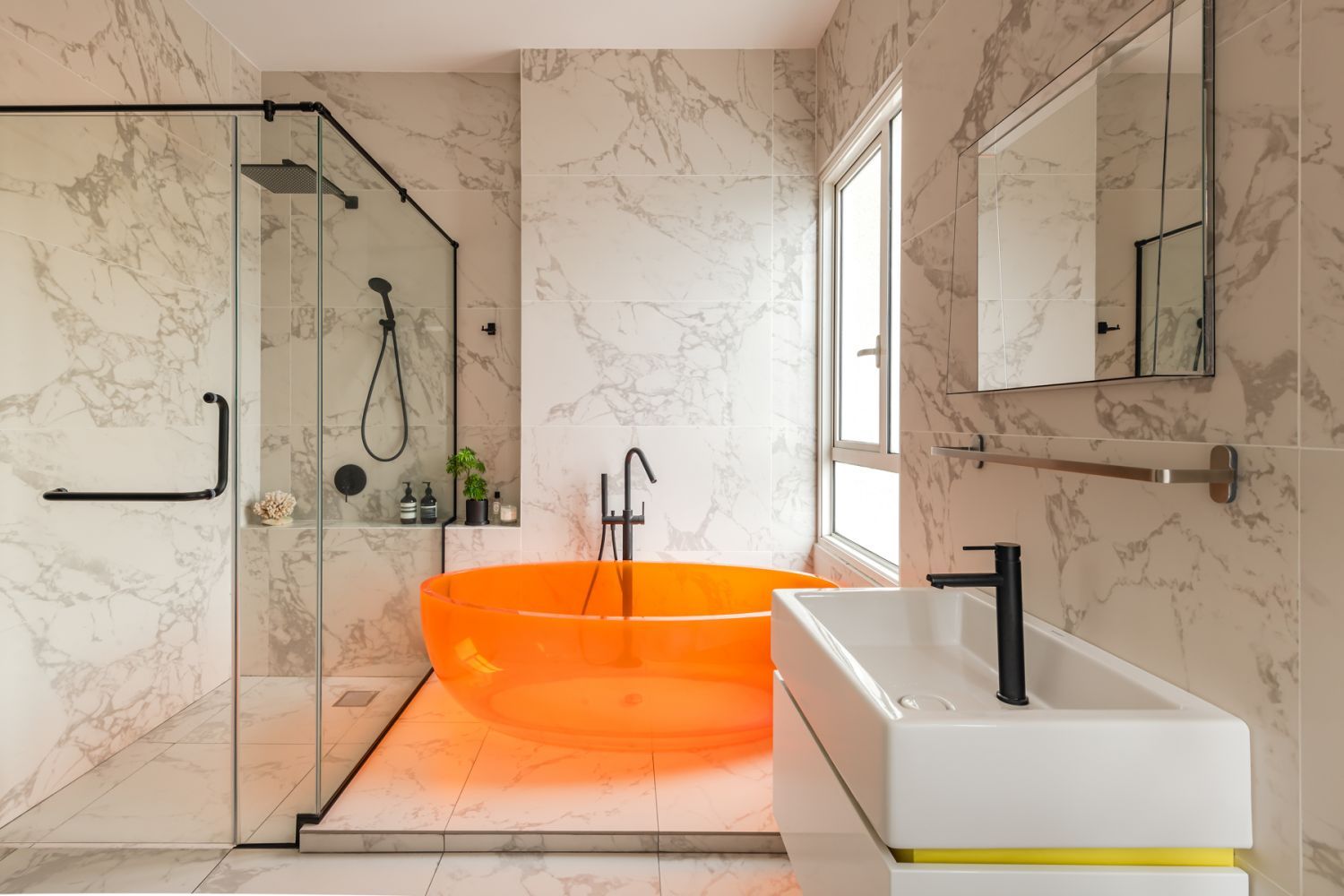 An orange bathtub is a bold statement in the otherwise monochromatic bathroom (Photo: David Yeow)