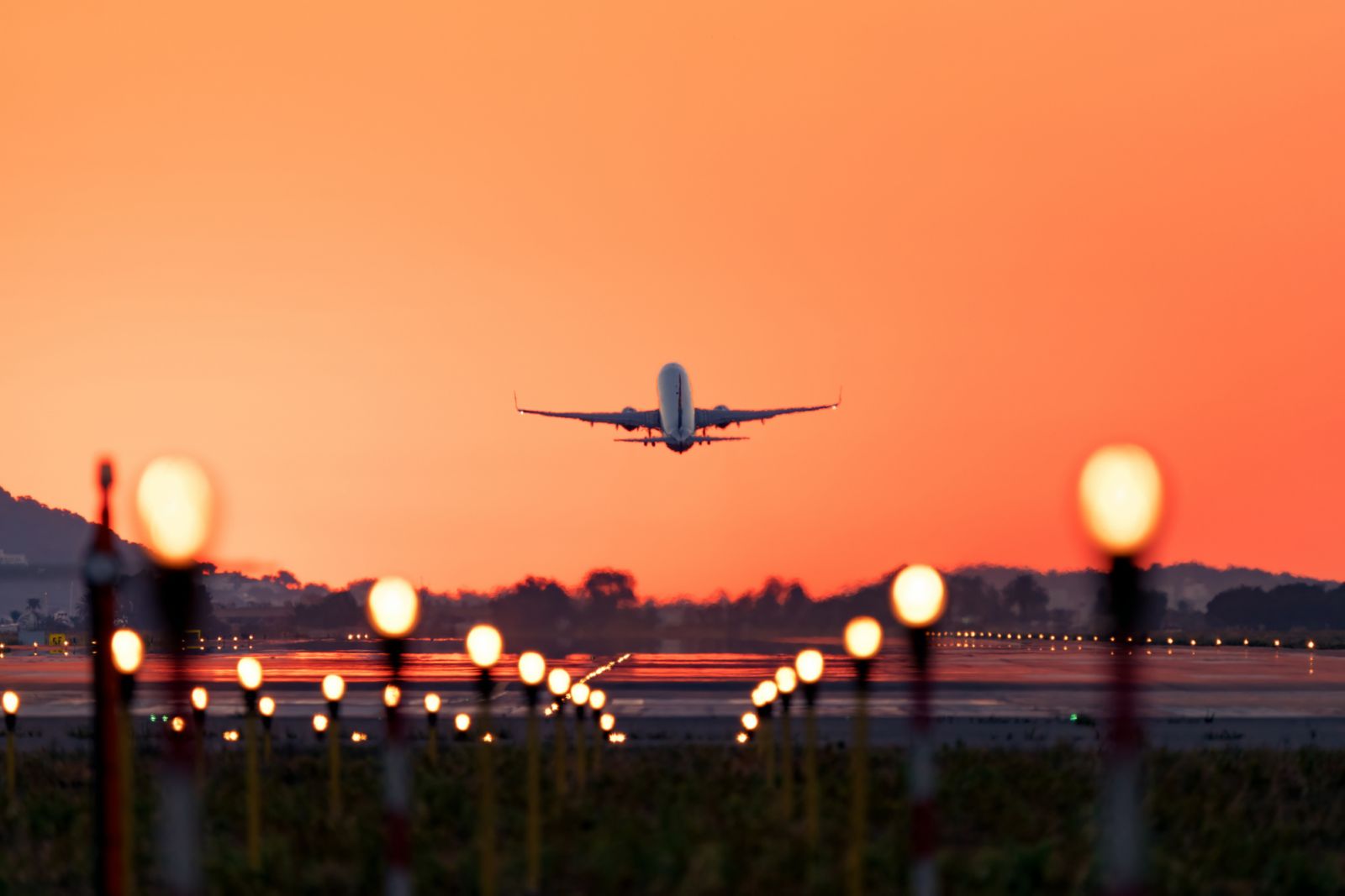 Airplane taking off at sunrise,