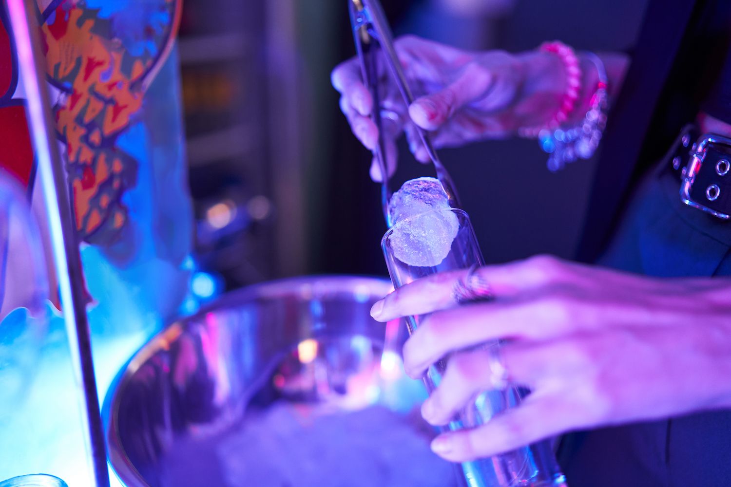 Waitress putting an ice cube in a glass in a disco club