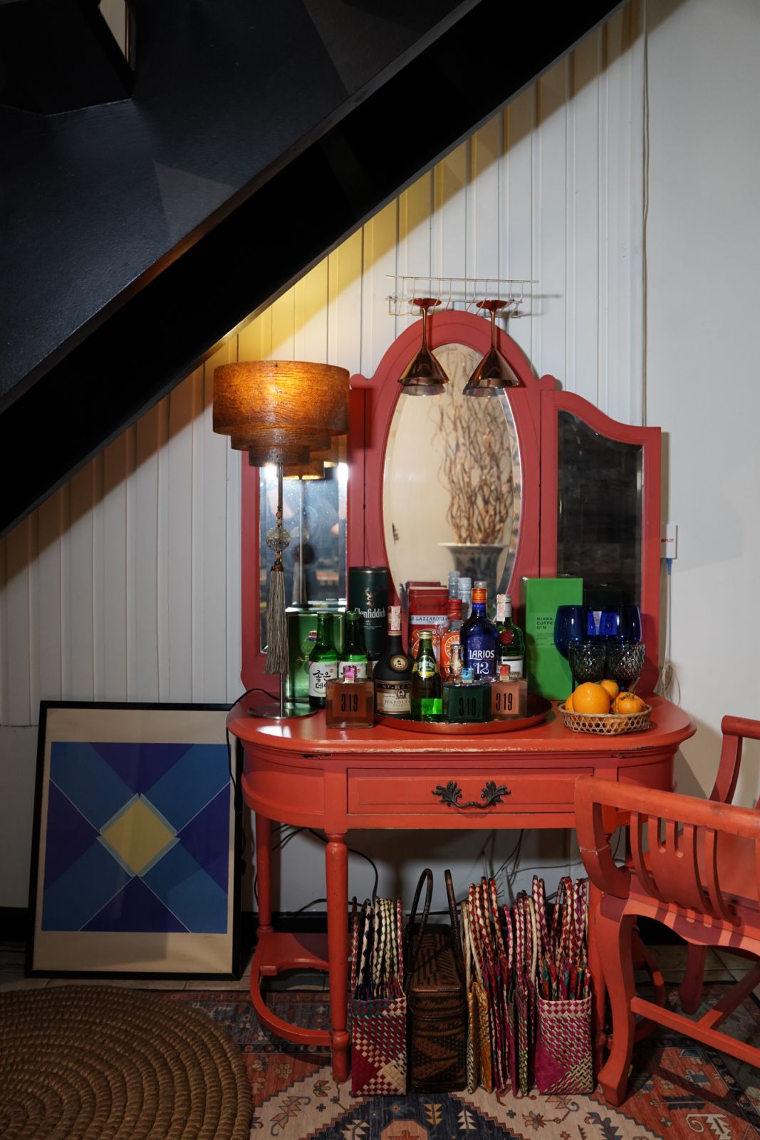 The antique dresser, repainted in a bright salmon, belonged to Bunag’s grandmother and has been converted into a mini-bar under the stairs