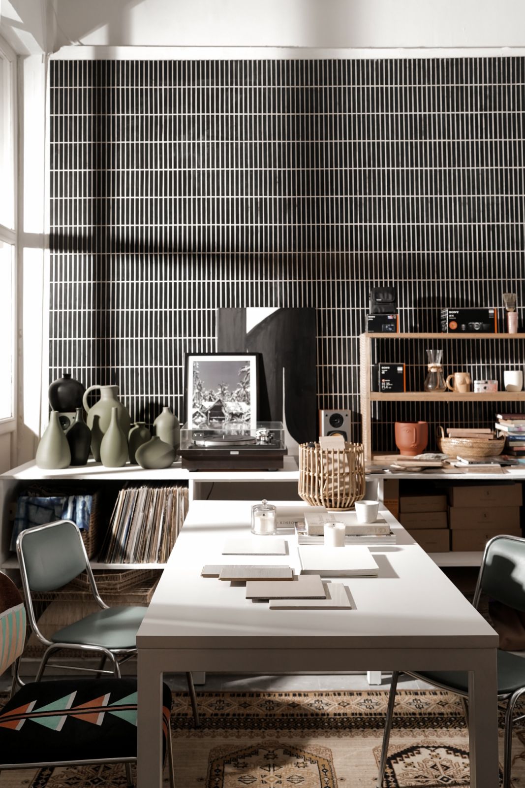 Her studio wall is peppered with travel photos, swatches and clay jars composed around her vinyl player and records collection