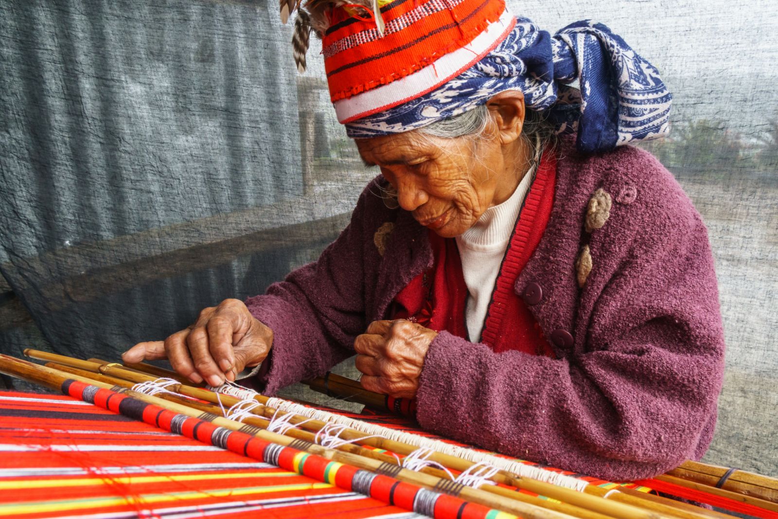 Ifugao (ancient culture of wet-rice agriculturalists) woman weaver in traditional dress and hat, Banaue, Luzon Island, Philippines (Photo: James Strachan/Getty Images)