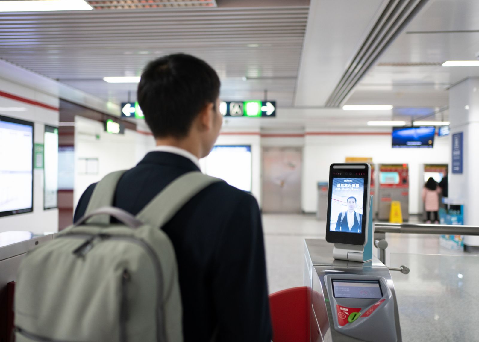 Asian men use facial recognition to pay subway fares