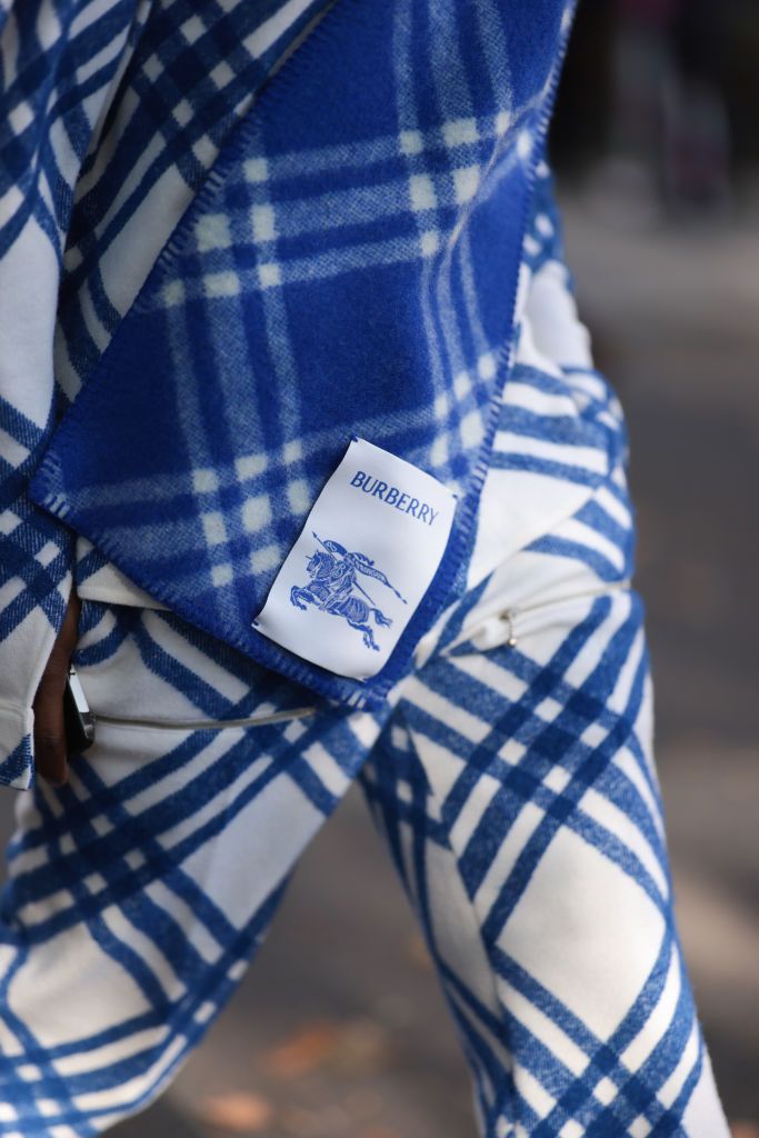 LONDON, ENGLAND - SEPTEMBER 18: SAINt JHN was seen wearing full white and blue Burberry look consisting of pants, a blazer and a scarf around his neck along with blue Chanel shades during London Fashion Week September 2023 at the Burberry Fashion Show on September 18, 2023 in London, England. (Photo by Jeremy Moeller/Getty Images)