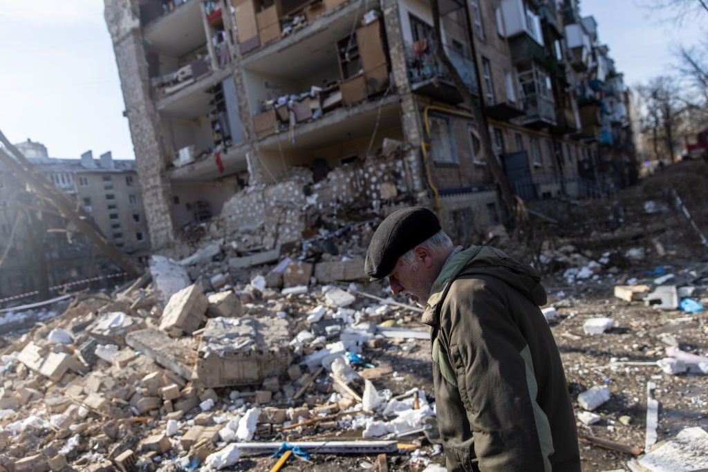 A man walks amid debris in front of a residential apartment complex that was heavily damaged by a Russian attack on March 18, 2022 in Kyiv, Ukraine. Russian forces remain on the outskirts of the Ukrainian capital, but their advance has stalled in recent days, even while Russian strikes, and pieces of intercepted missiles, have hit residential areas in the north of Kyiv