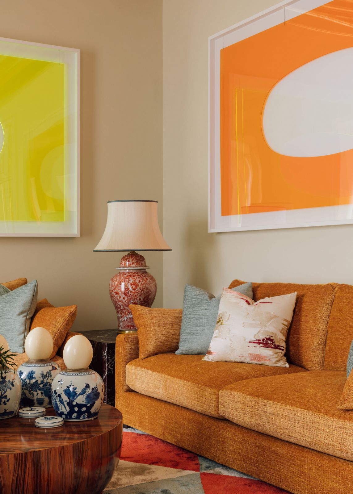 yellow and orange acrylic art framed above couches