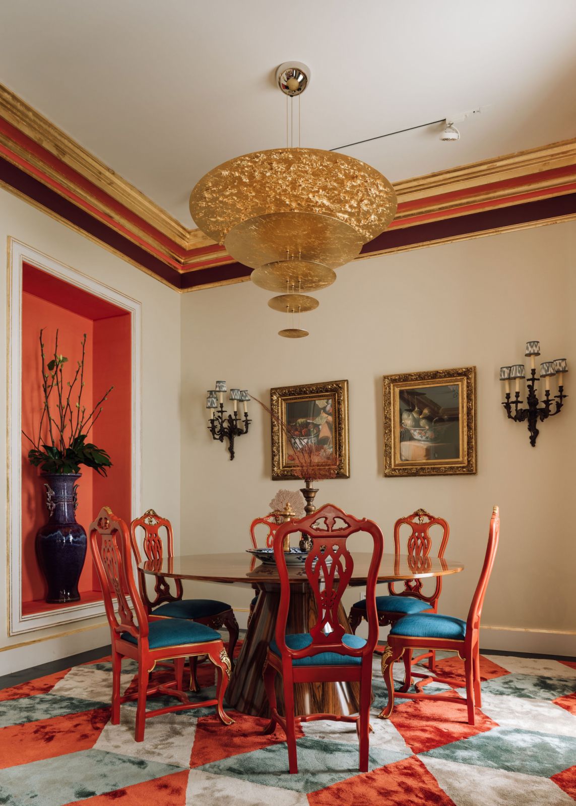 gold ornamental chandelier above table and 5 red chairs