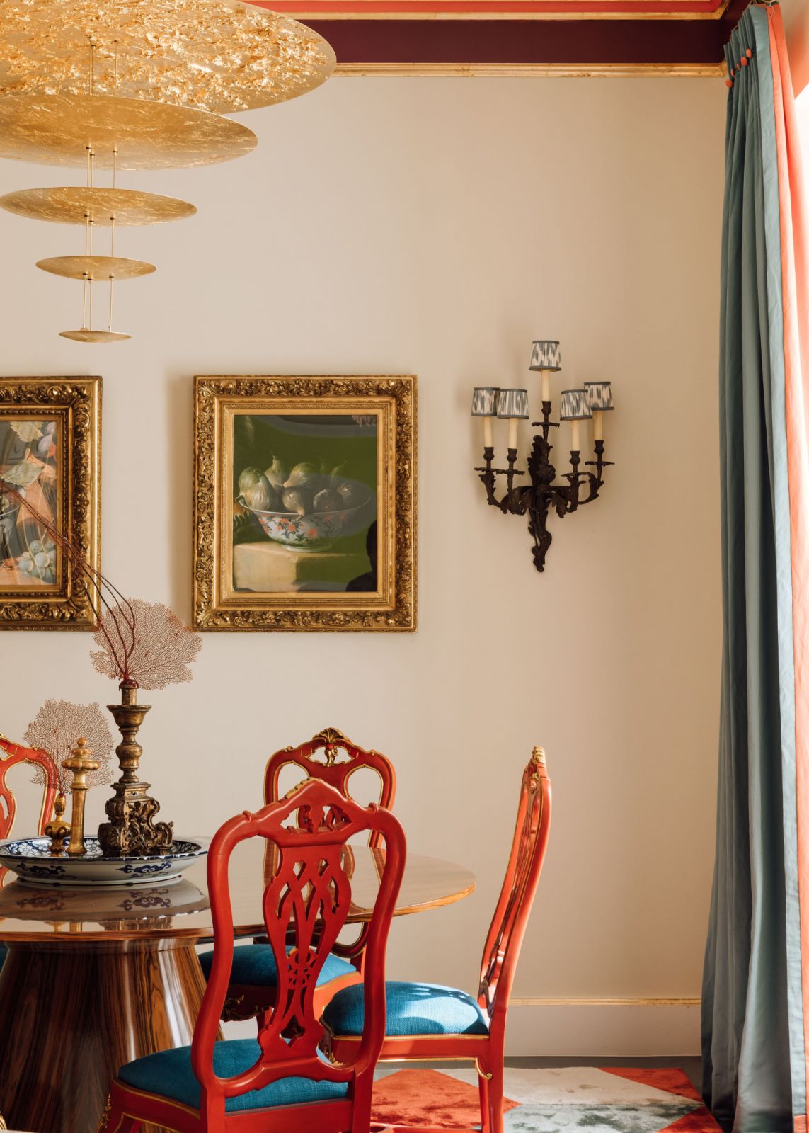 side shot of gold chandelier with ornamental red chairs
