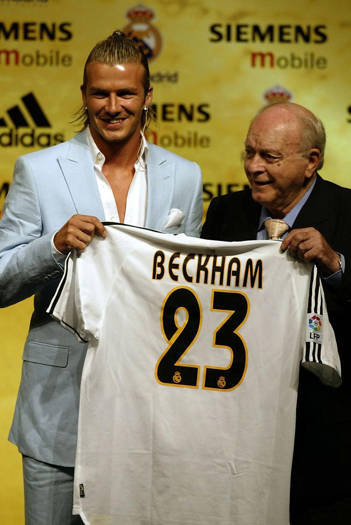 MADRID - JULY 2: David Beckham is given his new shirt and number by Real Madrid legend and greatest player of them all Alfredo Di Stefano at the Real Madrid press conference announcing his signing to Real Madrid on July 2, 2003 at the Pabellon Raimundo Saporta, in Madrid, Spain. (Photo by Ross Kinnaird/Getty Images)