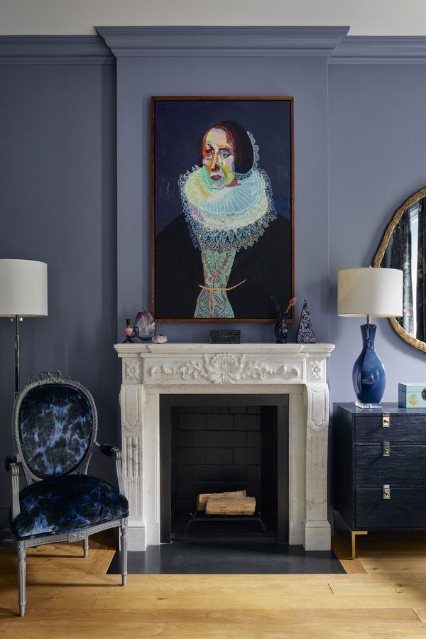 One of the several fireplaces within the townhouse, accompanied by an upholstered chair that has followed the clients from home to home