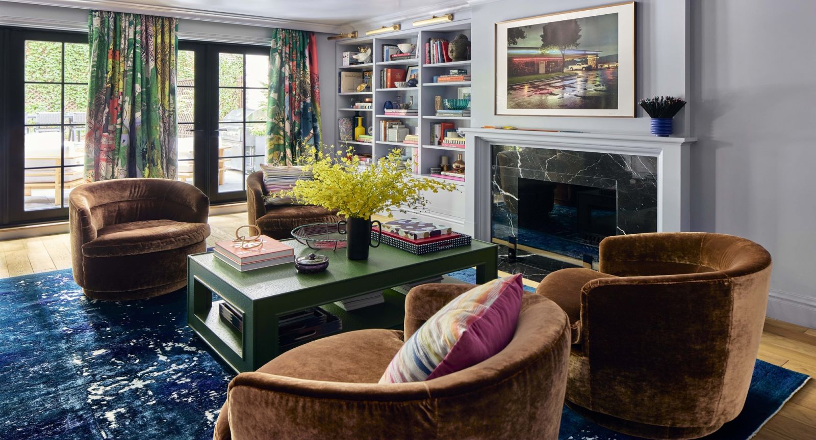 Velvet, patterns, and marble bring a playful pop of colour and character to this bright living room that overlooks the garden