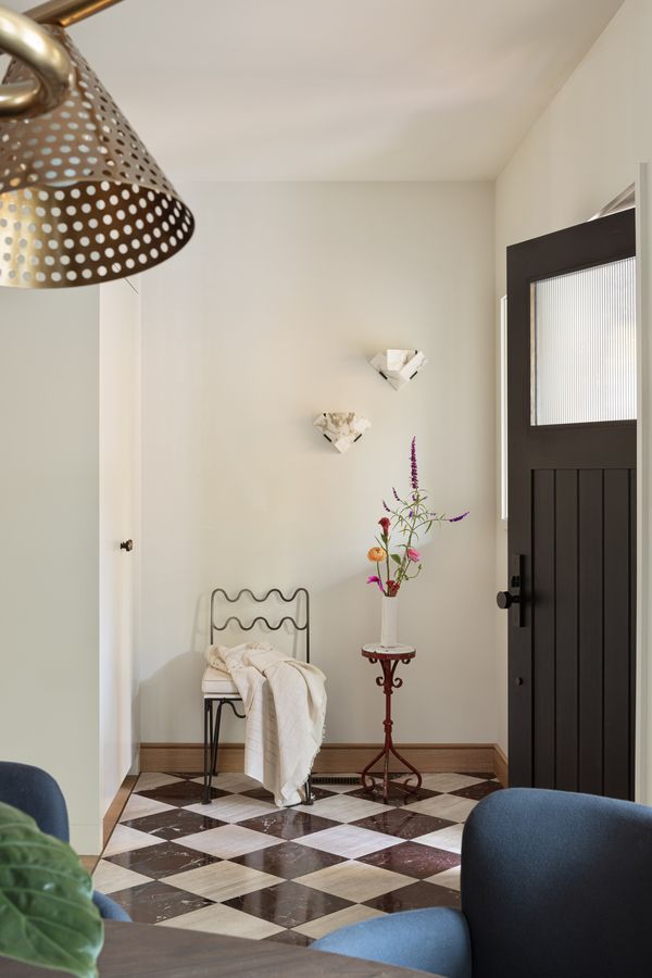 Checkered flooring and a few key pieces create a playful welcome at the front door
