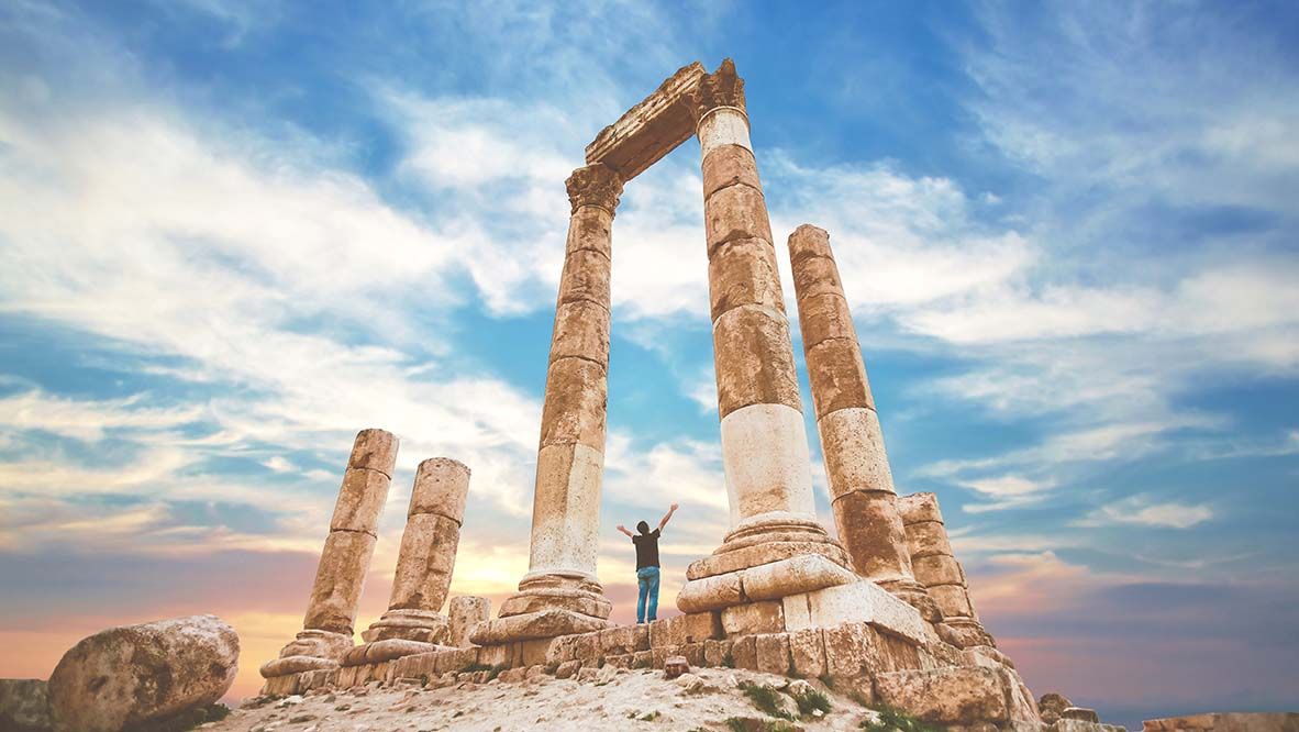 the citadel in the city of Amman in Jordan in the middle east at the sunset. Temple of Hercules of the Amman Citadel (Jabal al-Qal'a) with a young man