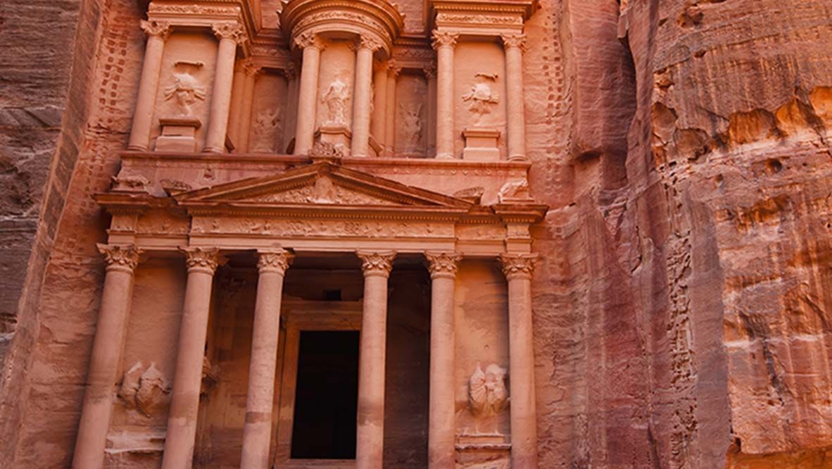 Camels resting in front of the Treasury, known locally as Al Khazneh, located in the UNESCO World Heritage Site of Petra, or Rose-Red city, which was the 6th century capital city of the Nabataeans.