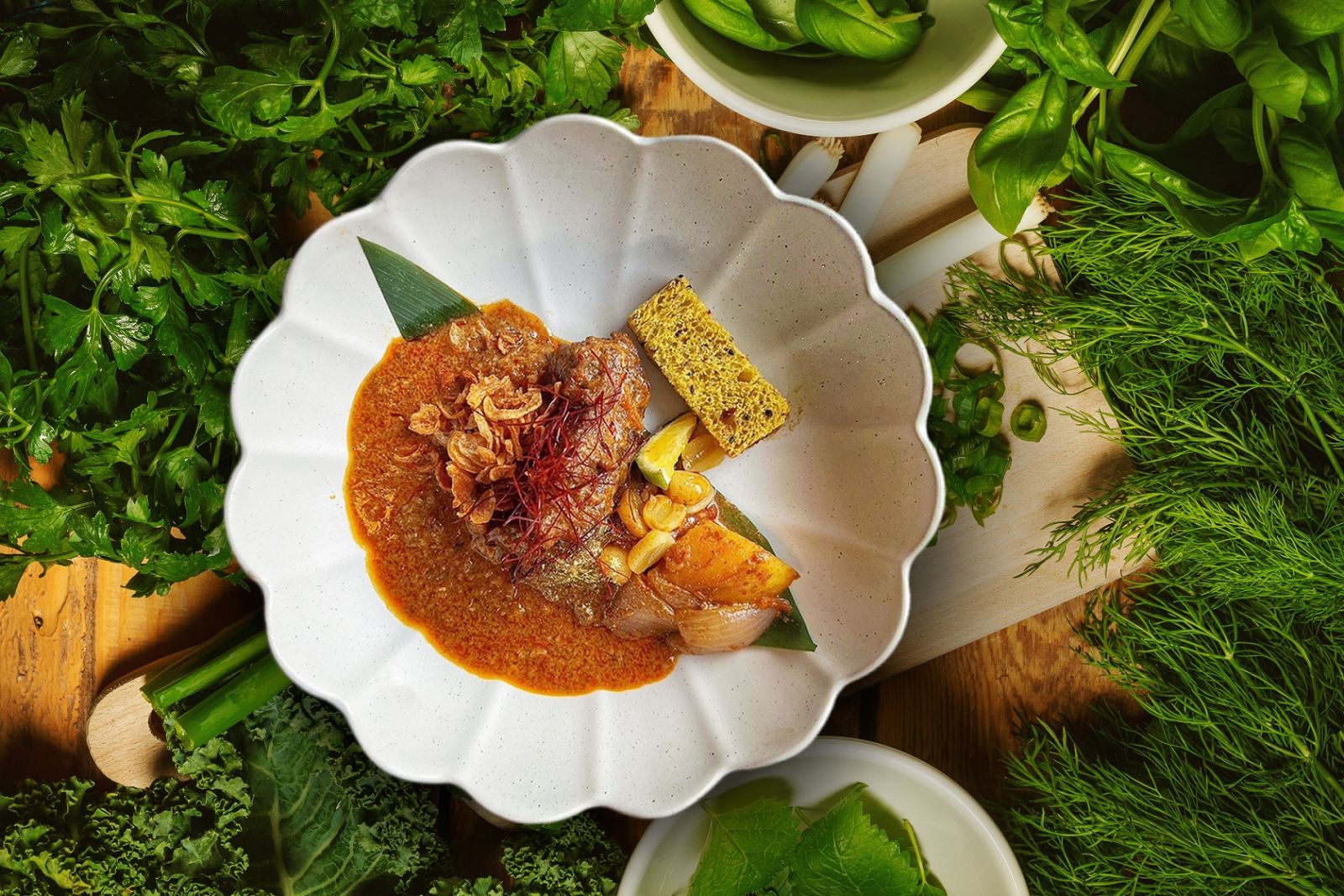 background with green vegetables and spices on a wooden table with a chopping board