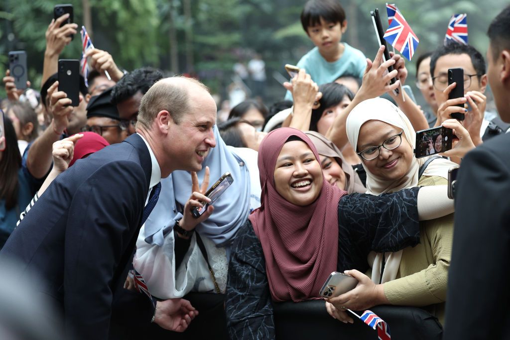 SINGAPORE, SINGAPORE - NOVEMBER 05: Prince William, Prince of Wales poses for a selfie with members of the public during his visit to the HSBC Rain Vortex at Jewel Changi Airport on day one of his visit to Singapore on November 05, 2023 in Singapore. The Prince of Wales is visiting Singapore to attend the Earthshot Prize Awards and will also carry out several engagements related to environmental issues. (Photo by Chris Jackson/Getty Images)