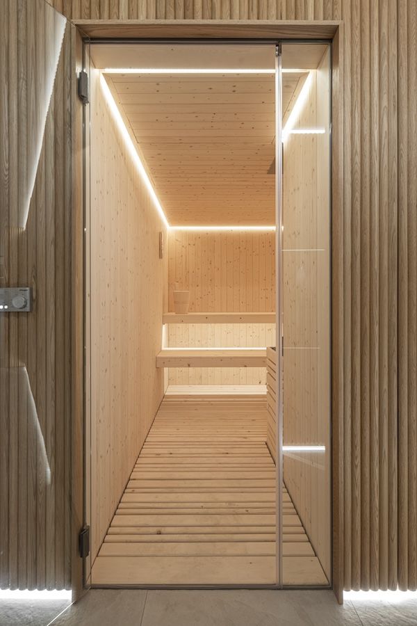 Frameless full-height doors in the sauna give a clean look to the doorway