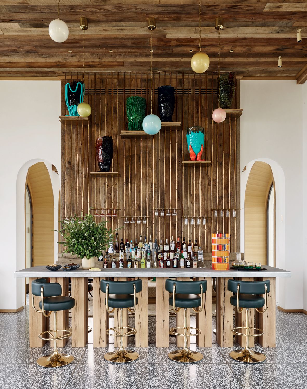 A playful array of decorative vessels by Gaetano Pesce creates visual interest next to the Lindsey Adelman pendant lights