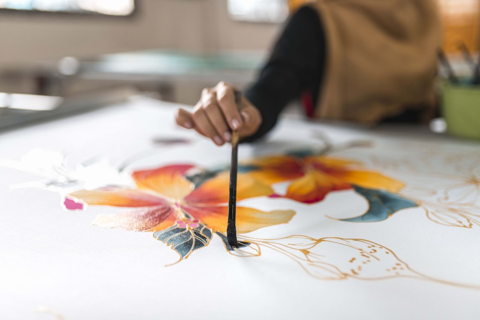 Close-up shot of woman painting in a batik workshop in Kuala Lumpur, Malaysia.