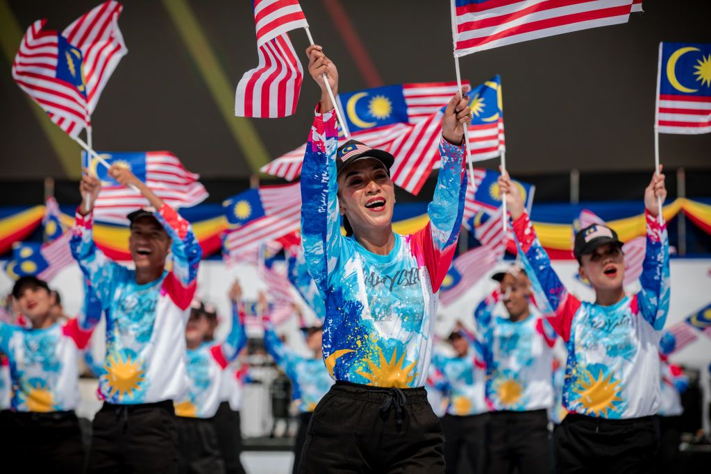 KUALA LUMPUR, MALAYSIA-AUGUST 31 : A group of dancers are performing while holding the Malaysian flag on the main stage during the 65th Independence Day celebration at Merdeka Square in Kuala Lumpur, Malaysia on August 31, 2022.It is estimated that more than 100,000.00 people have attended this National Day parade after 2 years of the Covid-19 Pandemic with the theme 'Keluarga Malaysia Teguh Bersama'. (Photo by Syaiful Redzuan/Anadolu Agency via Getty Images)