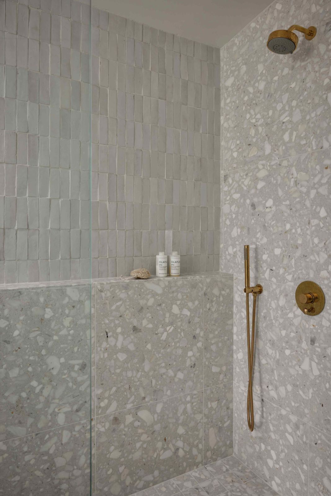 Textural zellige-tiled walls in the primary bathroom ensuite