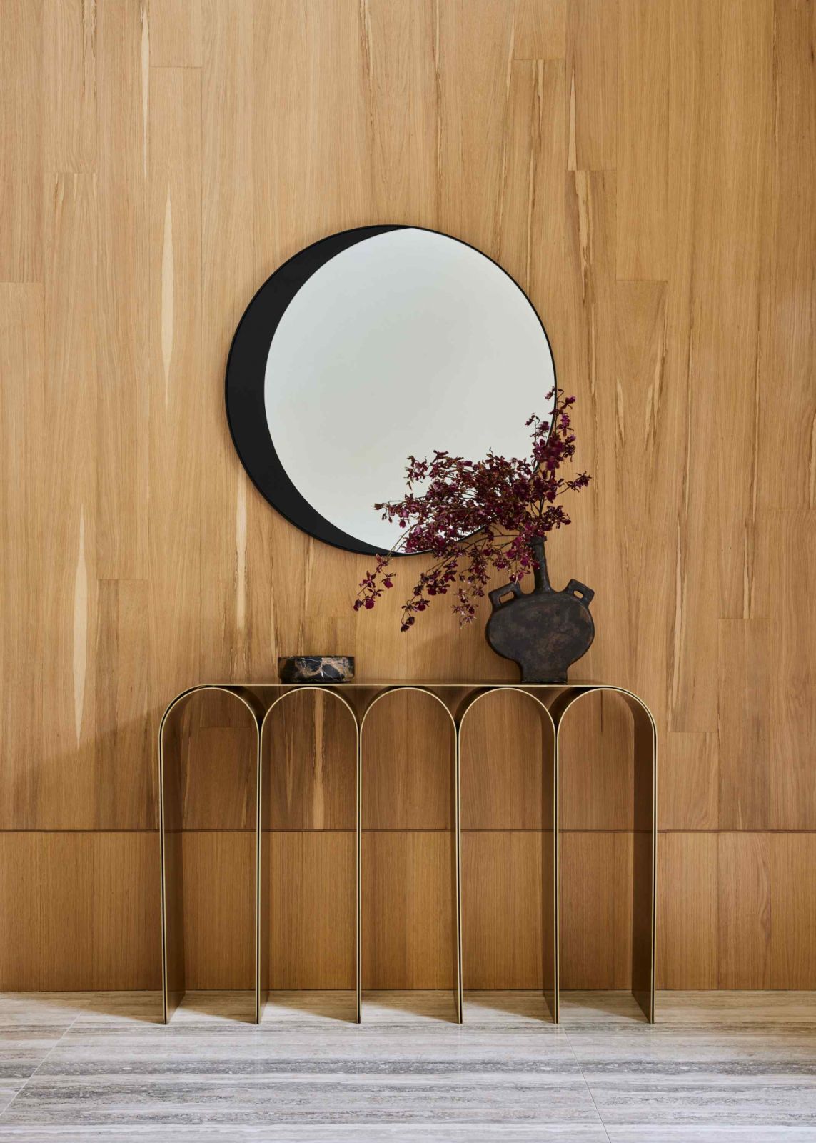 An arch brass console and orca mirror, with an artpiece by Jacob Hashimoto