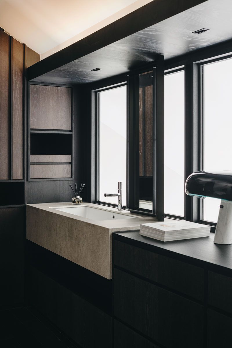 This elegant bathroom continues the minimalist scheme of the house with its elegant mix of dark wood and natural stone