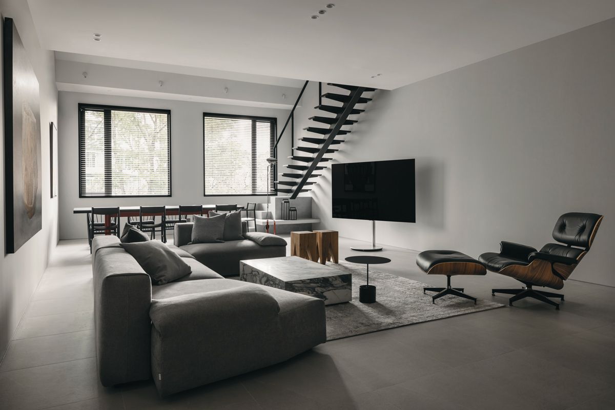 The neutral palette, accompanied by a tactile mix of materials, presents a serene ambience in the open-plan living room
