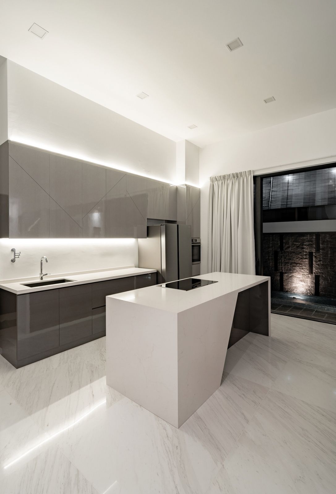 The angular form of the kitchen island creates a striking centrepiece in the culinary zone