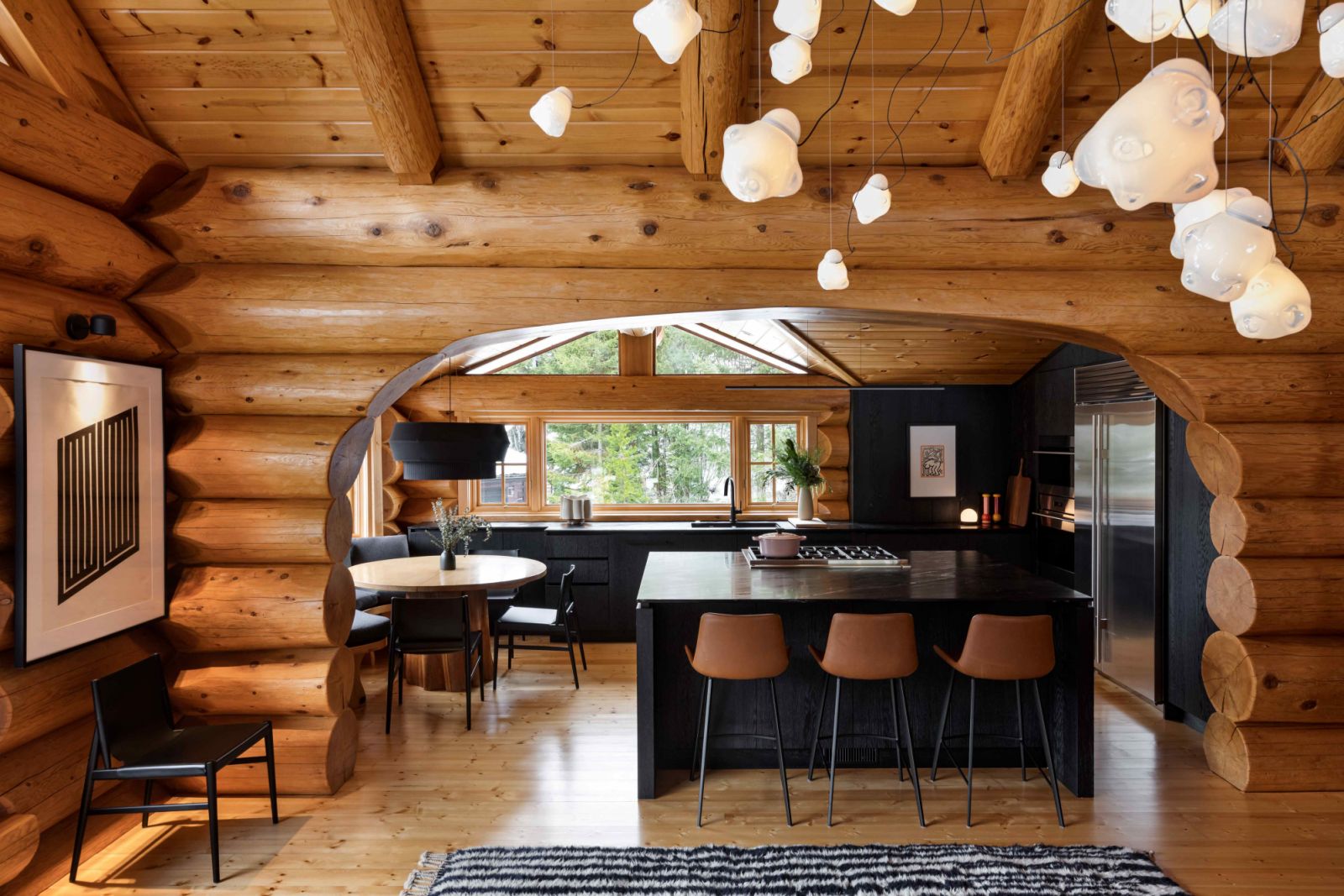 The existing log structure contrasted with dark stained or wire-brushed oak cabinetry