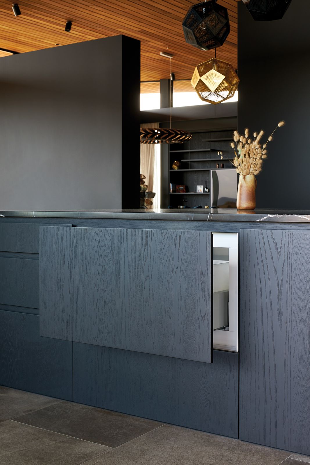 Appliances such as the CoolDrawer are beautifully incorporated into the dark-stained wood cabinetry in the kitchen