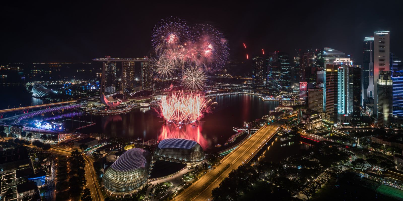 Marina Bay is at the center of Singapore's business district and also home to many hotels for visitors to the city state. Singapore's low tax rates and stable government are attractive for foreign investment. This view shows New Year fireworks along with Marina Bay Sands, ArtScience Museum, Central Business District, Esplanade, Merlion, One Fullerton and the Padang.