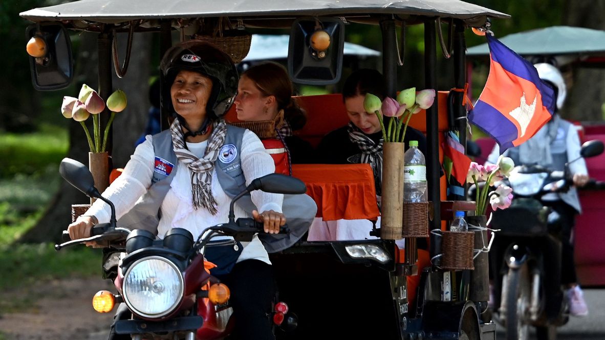 Female Tuk Tuk driver Kim Sokleang transporting her passengers near the Bayon temple at the Angkor complex in Siem Reap province (Photo: Agence France Presse)