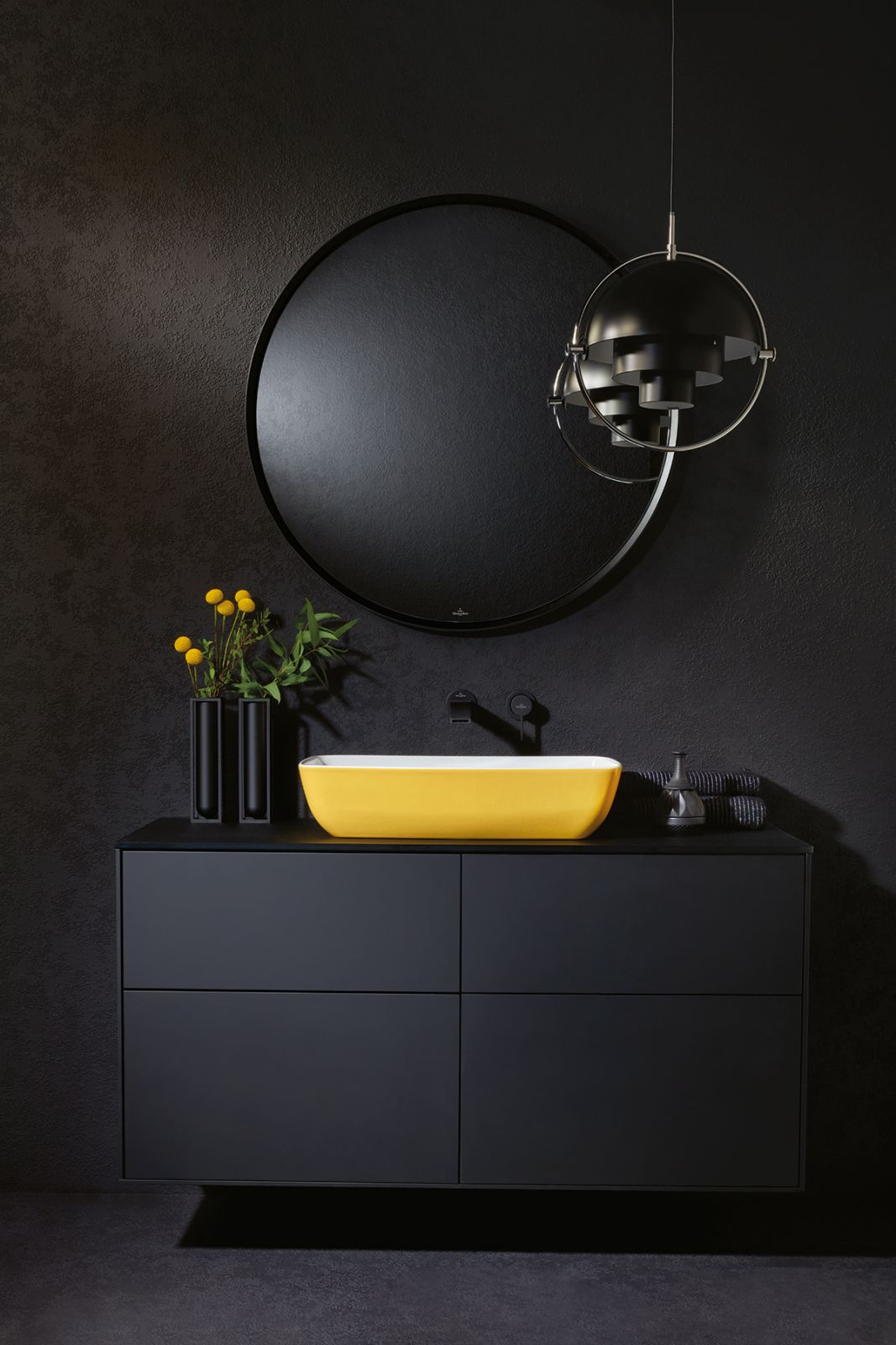 The energising yellow hue of the Artis washbasin in Indian Summer brings a cheerful touch to the moody black tones of this powder room