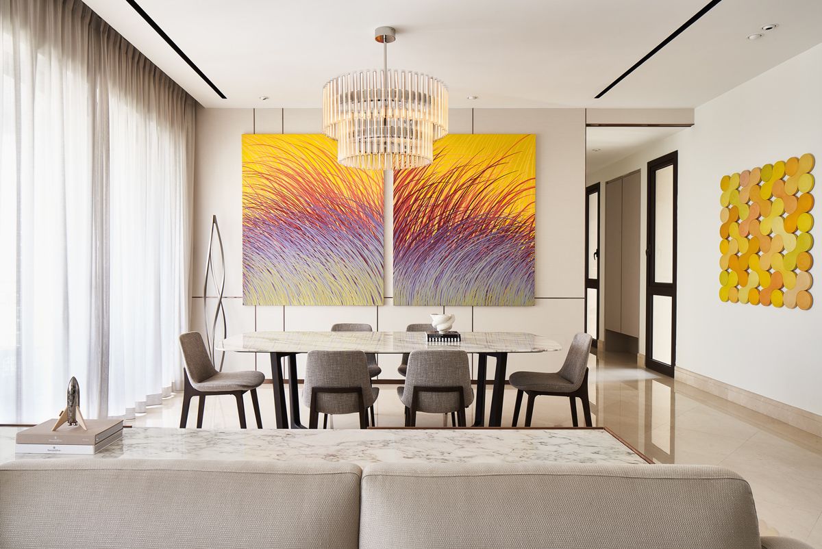 The zesty yellow hues of the abstract diptych painting are picked up by another equally eye-catching geometric artwork in the dining area