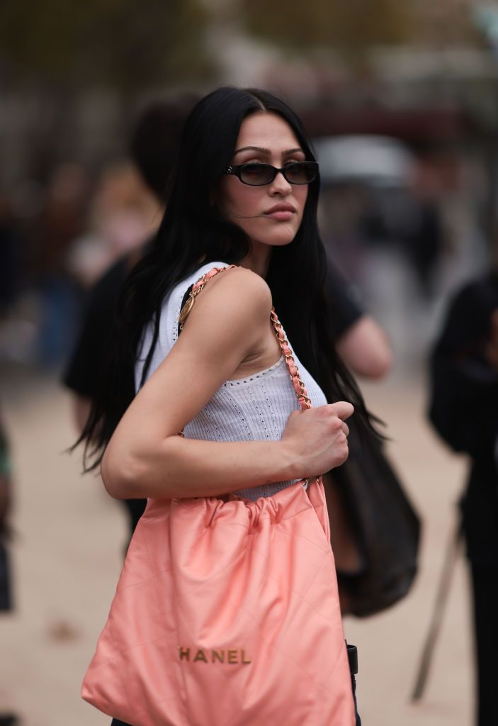 PARIS, FRANCE - OCTOBER 03: Amelia Gray is seen outside Chanel show wearing black Chanel sunnies, white Chanel tweed tank top and a peach colored Chanel 22 tote leather bag and dark blue low waist jeans during the Womenswear Spring/Summer 2024 as part of Paris Fashion Week on October 03, 2023 in Paris, France. (Photo by Jeremy Moeller/Getty Images)