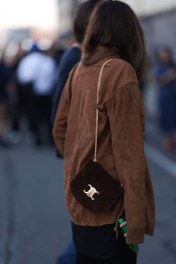 NEW YORK, NEW YORK - SEPTEMBER 12: Fashion show guest is seen wearing black pants, a brown jacket and a brown celine triomphe bag with golden ornaments before the Gabriela Hearst Fashion Show on September 12, 2023 in New York City. (Photo by Jeremy Moeller/Getty Images)
