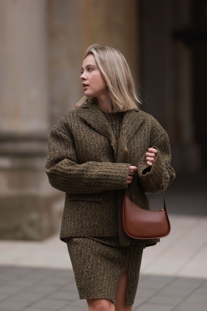 HAMBURG, GERMANY - NOVEMBER 12: Isabelle Hartmann seen wearing gold earrings, Miu Miu khaki green knit pullover, matching Miu Miu khaki green knit wool short jacket, matching Miu Miu khaki green knit wool short skirt, The Row brown leather bag, on November 12, 2023 in Hamburg, Germany. (Photo by Jeremy Moeller/Getty Images)