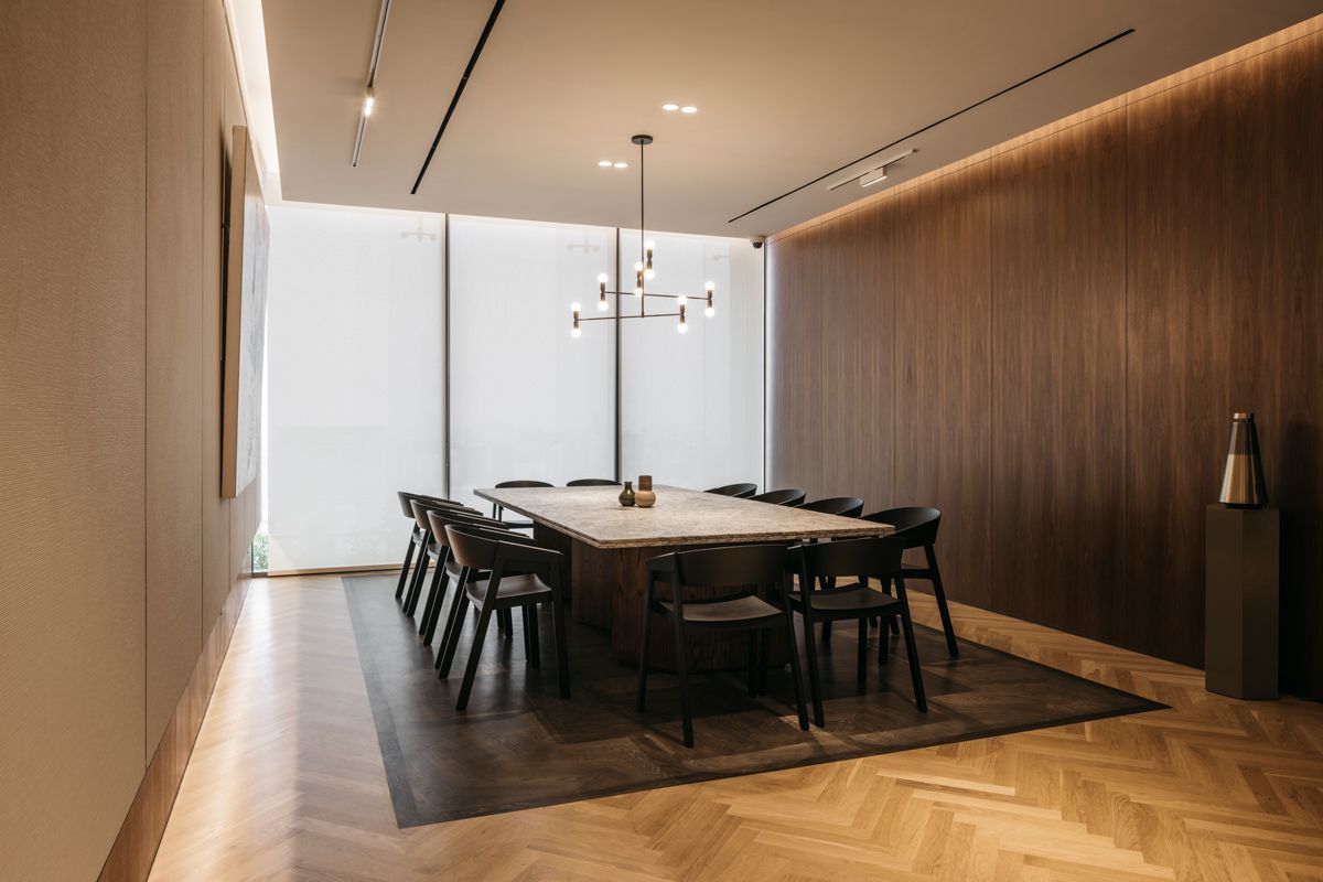 Herringbone-patterned flooring brings a tactile slant to the modern minimalist look of this meeting room