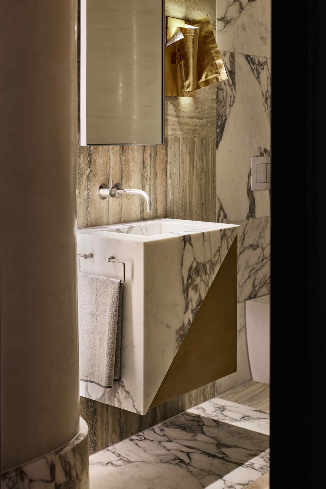 The custom made wall light of draped leather punctuated the dual-living residence