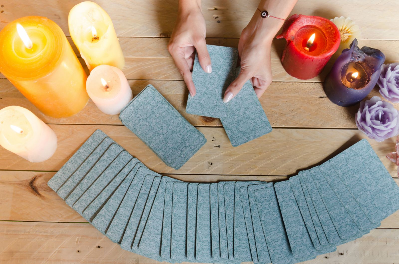 Fortune teller female hands and tarot cards on wooden table. Concept of divination.