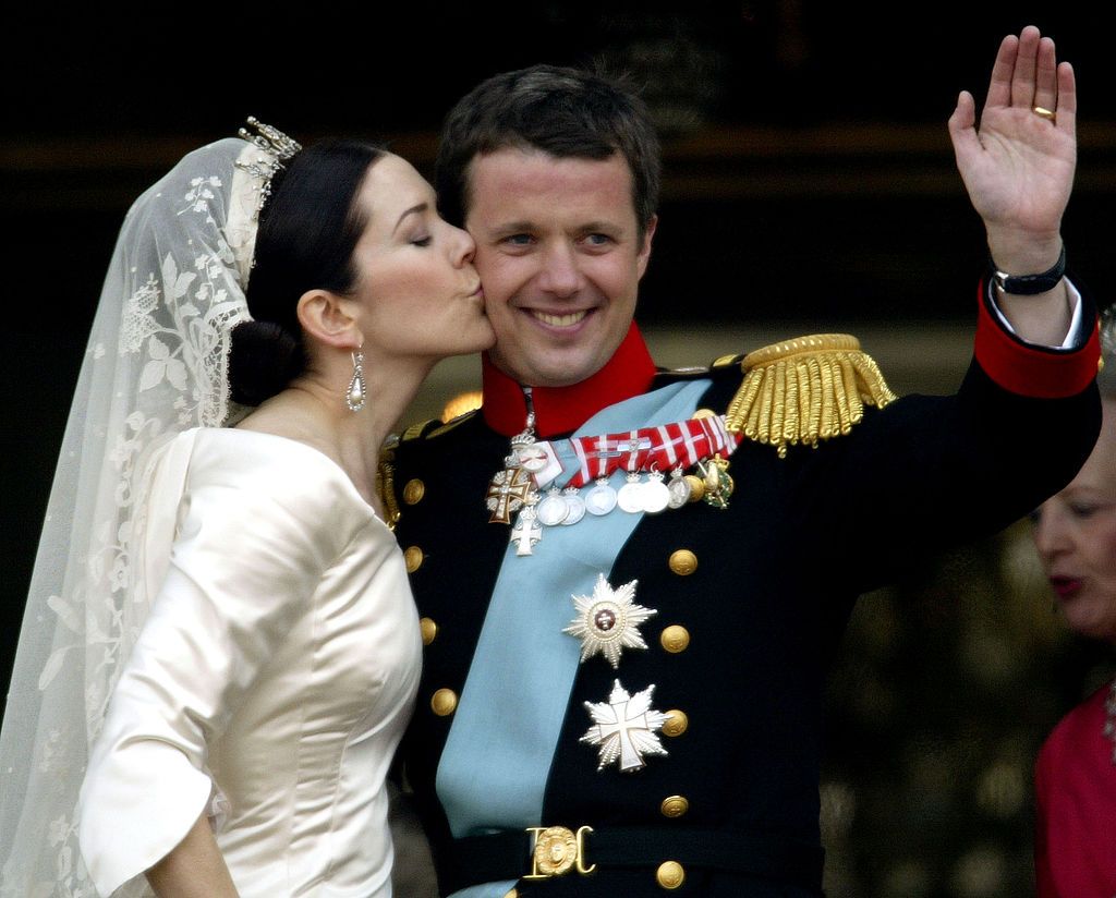 COPENHAGEN, DENMARK - MAY 14:  Danish Crown Prince Frederik and his bride Princess Mary kiss as the Royal couple appear on the balcony of Christian VII's Palace after their wedding May 14, 2004 in Copenhagen, Denmark. The romance began in 2000 when Miss Mary Elizabeth Donaldson met the heir to one of Europe's oldest monarchies over drinks at the Sydney Olympics, where he was with the Danish sailing team. (Photo by Ian Waldie/Getty Images)