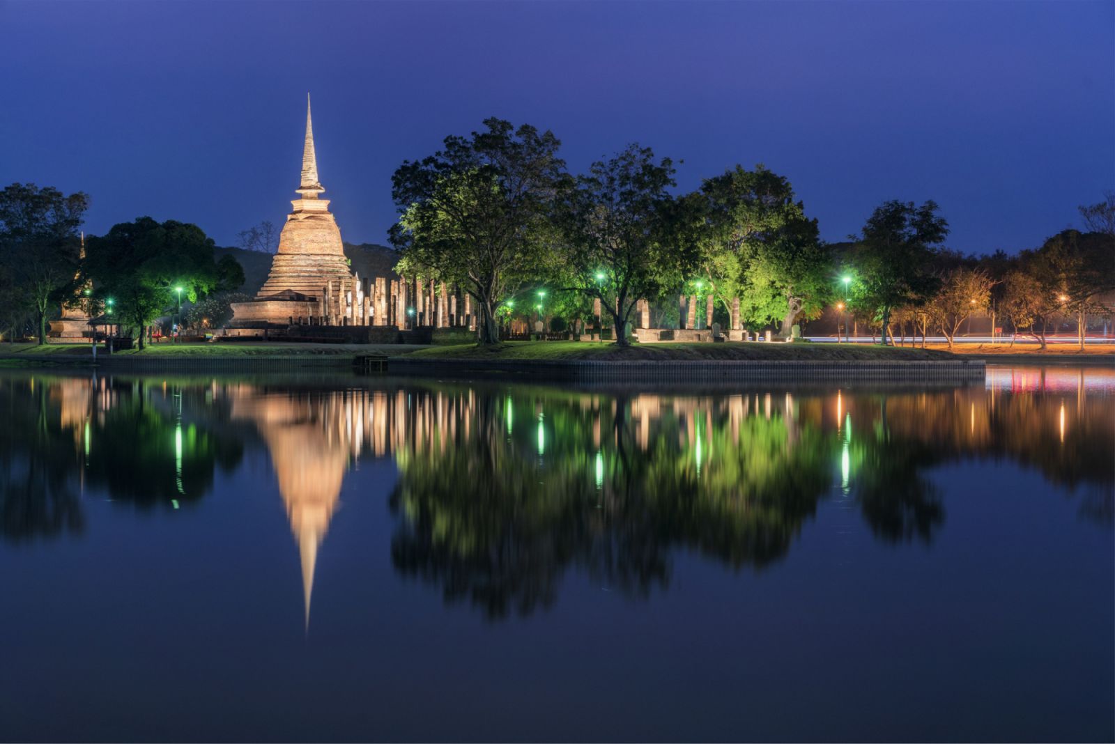 Ancient Thai temple with beautiful flourish flower at Sukhothai historical park after sunset.